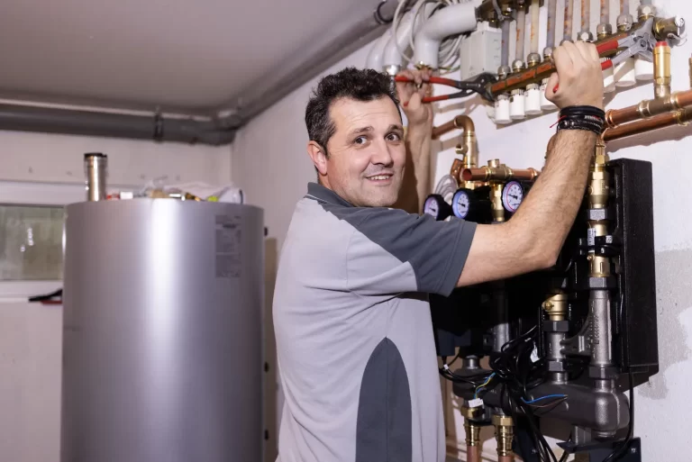 Heizungsinstallateur bei der Wartung einer Verteileranlage