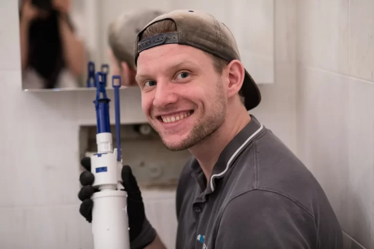 Installateur bei der Reparatur eines Spülkastens im Badezimmer